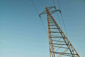 een elektrisch macht lijn tegen een blauw lucht foto