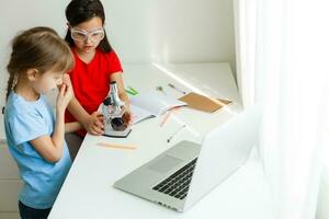 aan het leren van huis, huis school- kind concept. weinig kinderen studie online aan het leren van huis met laptop. quarantaine en sociaal afstand nemen concept. foto