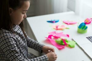 vrolijk schattig meisje kinderen opgewonden gebruik makend van computer aan het leren school werk. kind genieten e-learning in vakantie Bij huis. foto