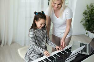 vrouw die haar dochter hielp piano te spelen, romp en toetsen van de piano werden digitaal aangepast foto