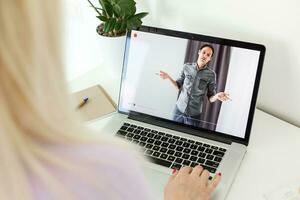 terug visie van een jong blond vrouw toetsenbord Aan laptop computer, intelligent vrouw leerling werken Aan netboek na haar lezingen in Universiteit foto