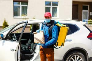 contactloos voedsel levering naar klanten huis. levering onderhoud arbeider met thermisch rugzak snel leveren voedsel Bij drempel in quarantaine van restaurant, supermarkt of cafe . online bestellen voedsel foto