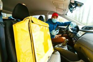 contactloos voedsel levering naar klanten huis. levering onderhoud arbeider met thermisch rugzak snel leveren voedsel Bij drempel in quarantaine van restaurant, supermarkt of cafe . online bestellen voedsel foto