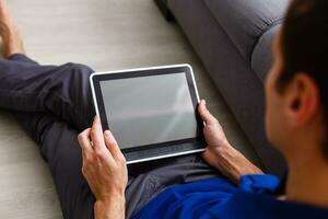 zakenman Holding een tablet computer met systeem knap huis foto