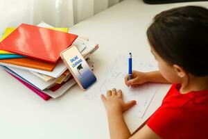 afstand aan het leren online opleiding, weinig meisje schrijft formules foto