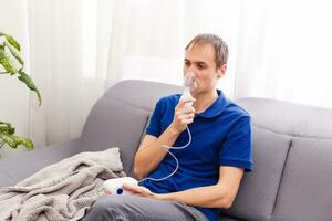 portret van jong Mens inademen door inhalator masker foto