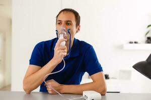 portret van jong Mens inademen door inhalator masker foto