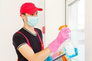 ontsmetting voor virus doden. arbeider in bescherming masker schoonmaak interieur gebruik makend van chemisch agenten naar hou op verspreiden virus infecties. foto