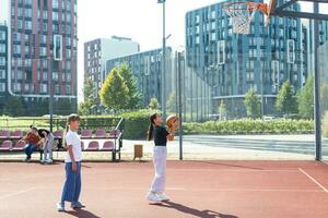 concept van sport, hobby's en gezond levensstijl. jong mensen spelen basketbal Aan speelplaats buitenshuis foto