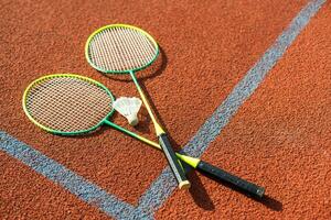 badminton shuttles en racket, geplaatst in de hoek van een synthetisch veld. foto