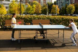 kind spelen tafel tennis buitenshuis met familie foto