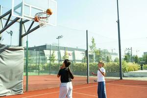 kinderen en sport. tiener- meisje spelen basketbal Aan de speelplaats. foto