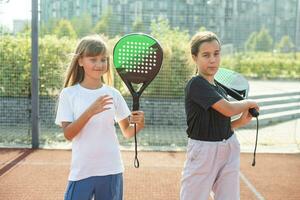 weinig meisje spelen peddelen tennis foto