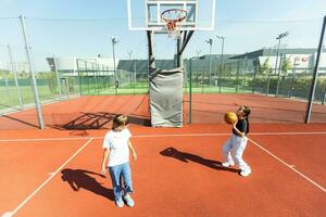 kinderen schoolkinderen spelen een bij elkaar passen over basketbal tegen de achtergrond foto