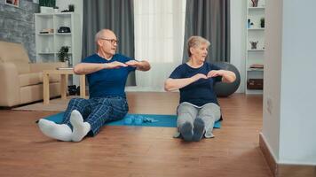 vrolijk senior paar opleiding samen zittend Aan yoga mat. oud persoon gezond en actief levensstijl oefening en training Bij huis, ouderen opleiding en geschiktheid foto