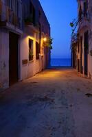 straat naar de zee in oud stad- Bij nacht ai generatief foto