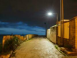 straat naar de zee in oud stad- Bij nacht ai generatief foto