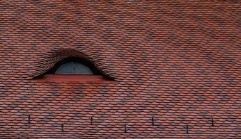 detail visie van een gebogen dak met een venster van een huis foto