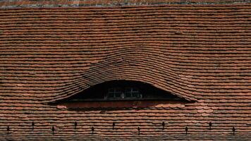 gebogen dak over- een venster van een oud huis foto