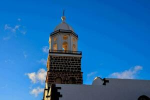 de toren van een kerk tegen een blauw lucht foto