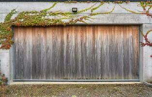 houten poort van garage met herfst bladeren klimop fabriek in de huis foto