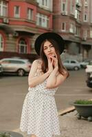 een jong tiener- meisje in een wit jurk en hoed foto