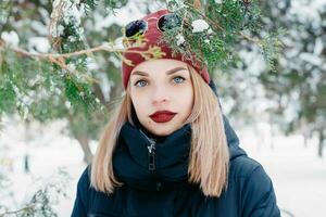 winter vrouw blazen sneeuw in een park foto