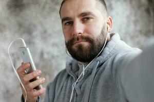 Mens in studio zet oor telefoons uit naar muziek. foto