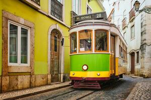 beroemd wijnoogst geel tram 28 in de versmallen straten van Alfama wijk in Lissabon, Portugal foto