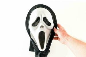 een persoon Holding een schreeuw masker over- een wit achtergrond foto
