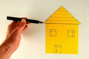 een persoon is tekening een huis Aan een wit bord foto