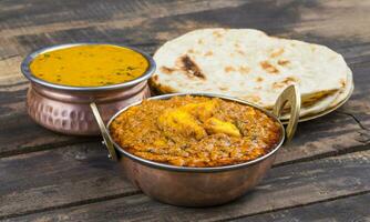Indisch voedsel kadai paneer geserveerd met dal makhani, tandoori of papad Aan houten achtergrond foto