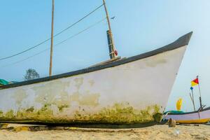 oud visvangst boten in zand Aan oceaan in Indië Aan blauw lucht achtergrond foto