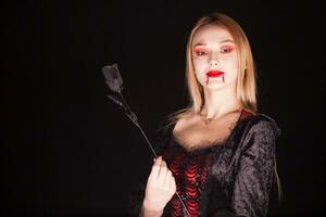 Kaukasisch vampier vrouw met bloederig lippen over- zwart achtergrond. halloween kostuum. foto