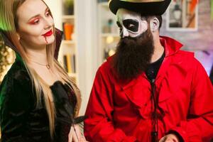 Mens gekleed omhoog Leuk vinden een piraat proberen naar verleiden vampier vrouw Bij halloween feest. foto