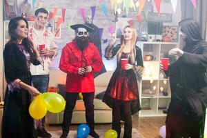 groep van vrienden met halloween kostuums dansen en lachend. foto