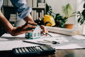 architect Mens werken met laptop en blauwdrukken, ingenieur inspectie in werkplaats voor bouwkundig plannen, schetsen een bouw project ,selectief focus, zaken concept wijnoogst kleur foto