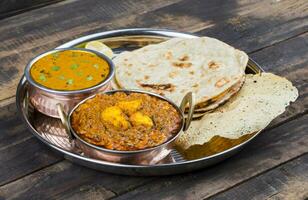 Indisch traditioneel thali voedsel kadai paneer geserveerd met dal makhani Aan wijnoogst houten achtergrond foto