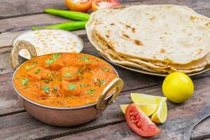 Indisch heerlijk keuken paneer tikka masala met tandoori chapati Aan houten achtergrond foto