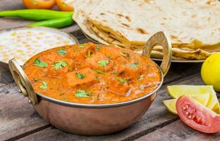 Indisch heerlijk keuken paneer tikka masala met tandoori chapati Aan houten achtergrond foto