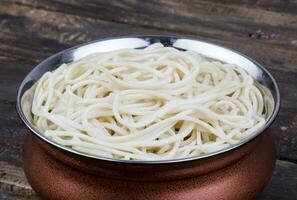 gekookt chow mein of hakka noedels Aan houten achtergrond foto