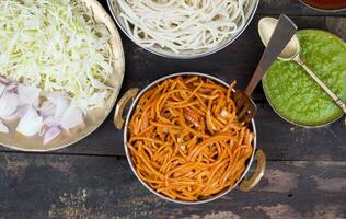 pittig gebakken groente veg chow mein Aan houten tafel foto