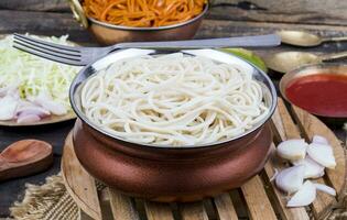 gekookt chow mein of hakka noedels geserveerd met chutney Aan houten achtergrond foto