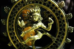 een goud standbeeld van een Hindoe god in een circulaire kader foto