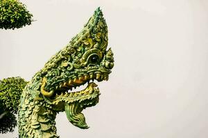 een draak standbeeld met groen en goud decoraties foto