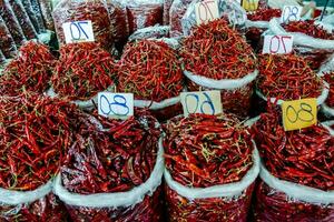 een groot stapel van rood Chili paprika's in Tassen foto