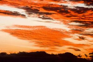 een rood lucht met wolken foto