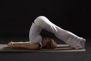 vrouw oefenen yoga binnen- Aan zwart achtergrond, foto