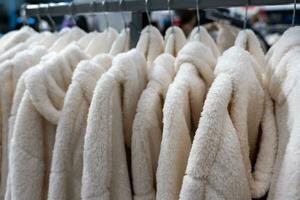 assortiment van pluche beige warm huisjassen hangende Aan plank in kleding op te slaan foto