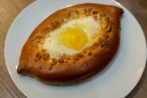 heerlijk khachapuri, traditioneel Georgisch kaas brood met ei, geserveerd Aan cafe tafel foto